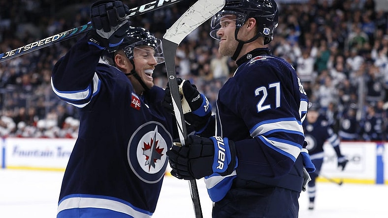 Nov 14, 2023; Winnipeg, Manitoba, CAN; Winnipeg Jets left wing Nikolaj Ehlers (27) celebrates his second period goal with Winnipeg Jets defenseman Nate Schmidt (88) against the New Jersey Devils at Canada Life Centre. Mandatory Credit: James Carey Lauder-USA TODAY Sports
