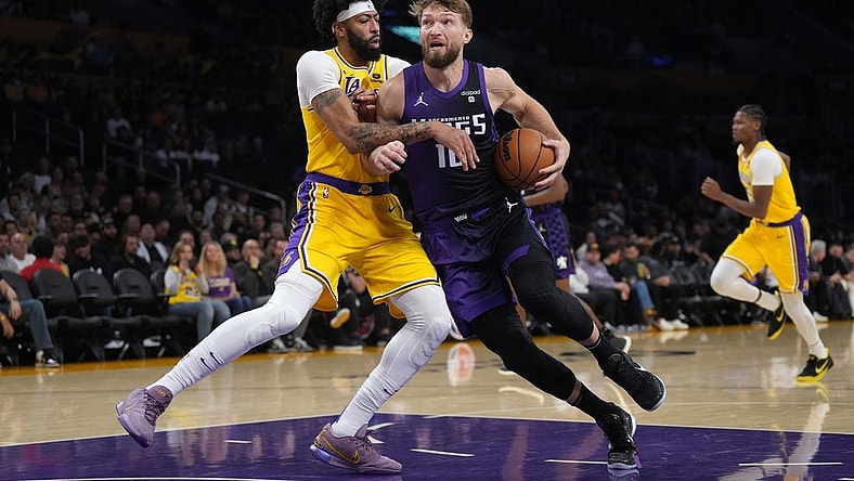 Nov 15, 2023; Los Angeles, California, USA; Sacramento Kings forward Domantas Sabonis (10) is defended by Los Angeles Lakers forward Anthony Davis (3) in the first half at Crypto.com Arena. Mandatory Credit: Kirby Lee-USA TODAY Sports
