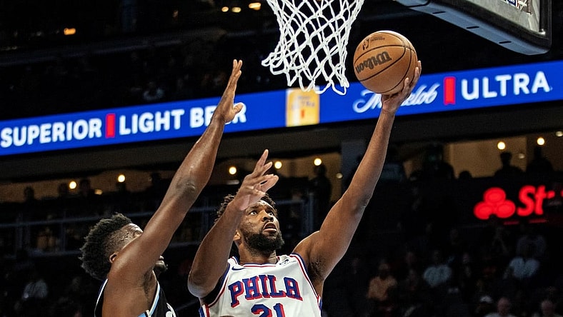 Nov 17, 2023; Atlanta, Georgia, USA; Philadelphia 76ers center Joel Embiid (21) shoots layup against Atlanta Hawks center Clint Capela (15) during the first quarter at State Farm Arena. Mandatory Credit: Jordan Godfree-USA TODAY Sports