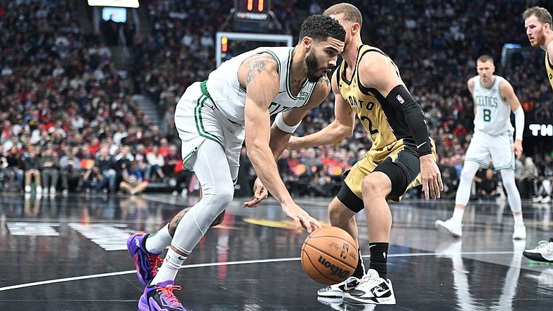 Nov 17, 2023; Toronto, Ontario, CAN;   Boston Celtics forward Jayson Tatum (0) dribbles the ball past Toronto Raptors guard Malachi Flynn (22) in the first half at Scotiabank Arena. Mandatory Credit: Dan Hamilton-USA TODAY Sports