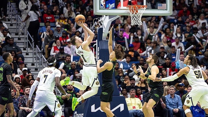 Nov 17, 2023; New Orleans, Louisiana, USA;  Denver Nuggets guard Christian Braun (0) shoots a jump shot against New Orleans Pelicans guard Dyson Daniels (11) during the second half at the Smoothie King Center. Mandatory Credit: Stephen Lew-USA TODAY Sports