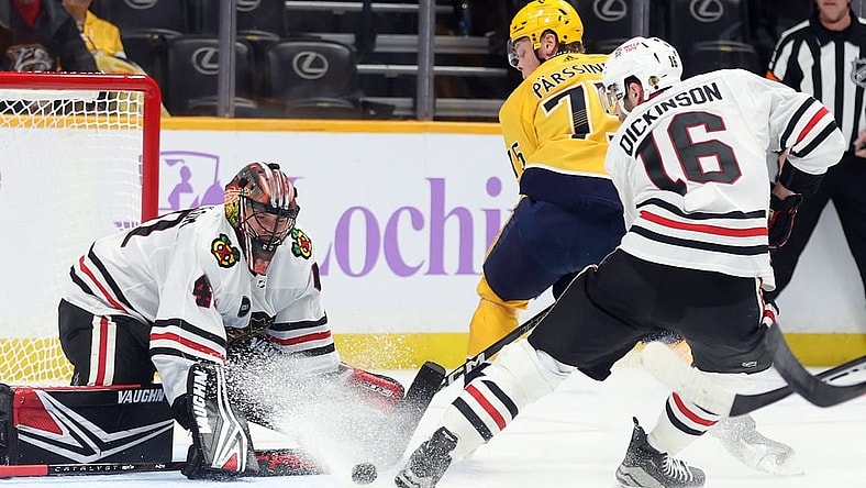 Nov 18, 2023; Nashville, Tennessee, USA;  Nashville Predators player Juuso Parssinen (75) shoots against Chicago Blackhawks players Arvid Soderblom (40) and player Jason Dickinson (16) during the first period of their game at Bridgestone Arena. Mandatory Credit: Alan Poizner-USA TODAY Sports