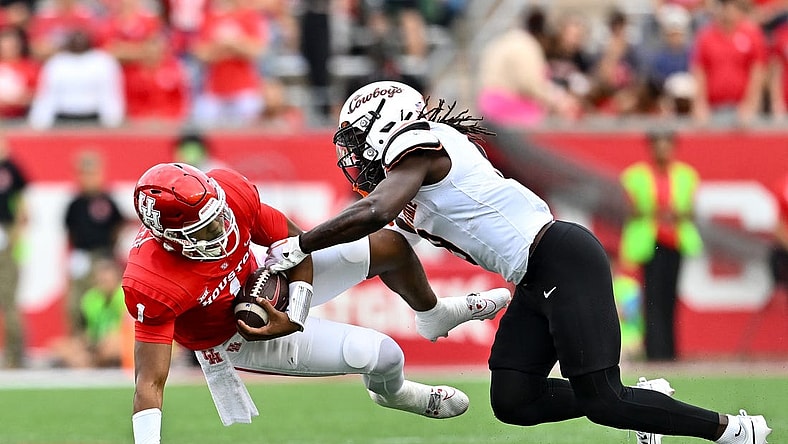 Nov 18, 2023; Houston, Texas, USA; Oklahoma State Cowboys safety Trey Rucker (9) tackles Houston Cougars quarterback Donovan Smith (1) during the first half at TDECU Stadium. Mandatory Credit: Maria Lysaker-USA TODAY Sports