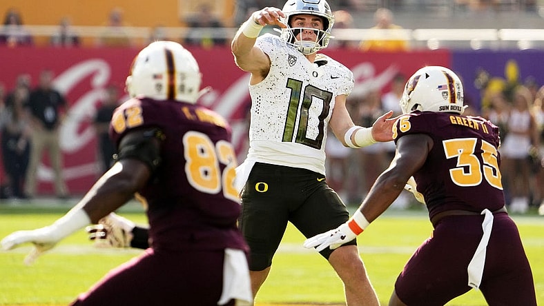 Nov 18, 2023; Tempe, Arizona, USA; Oregon Ducks quarterback Bo Nix (10) throws a touchdown pass with pressure from Arizona State Sun Devils defensive lineman B.J. Green II (35) in the first half at Mountain America Stadium. Mandatory Credit: Rob Schumacher-Arizona Republic