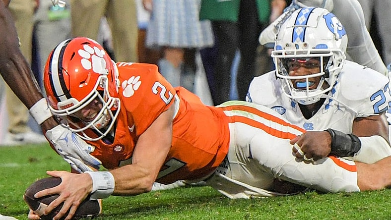 Nov 18, 2023; Clemson, South Carolina, USA; Clemson Tigers quarterback Cade Klubnik (2) dives past North Carolina Tar Heels linebacker Power Echols (23) for a touchdown during the second quarter at Memorial Stadium. Mandatory Credit: Ken Ruinard-USA TODAY Sports