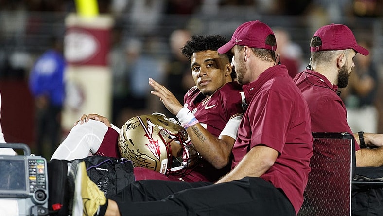 Nov 18, 2023; Tallahassee, Florida, USA; Florida State Seminoles quarterback Jordan Travis (13) waves to fans while being carted off after an injury against the North Alabama Lions during the first quarter at Doak S. Campbell Stadium. Mandatory Credit: Morgan Tencza-USA TODAY Sports
