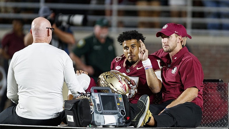 Nov 18, 2023; Tallahassee, Florida, USA; Florida State Seminoles quarterback Jordan Travis (13) waves to fans while being carted off after an injury against the North Alabama Lions during the first quarter at Doak S. Campbell Stadium. Mandatory Credit: Morgan Tencza-USA TODAY Sports