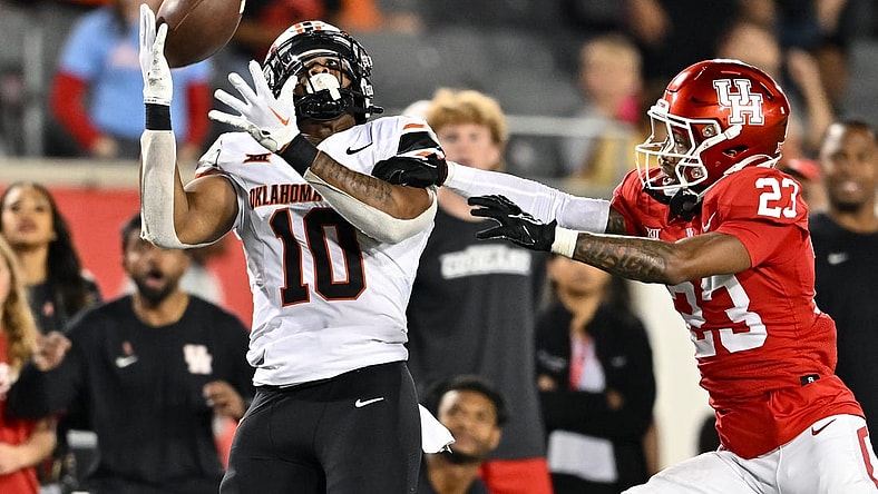 Nov 18, 2023; Houston, Texas, USA; Oklahoma State Cowboys wide receiver Rashod Owens (10) catches a pass during the fourth quarter as Houston Cougars defensive back Isaiah Hamilton (23) defends at TDECU Stadium. Mandatory Credit: Maria Lysaker-USA TODAY Sports