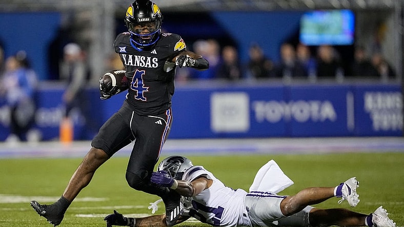 Nov 18, 2023; Lawrence, Kansas, USA; Kansas Jayhawks running back Devin Neal (4) runs the ball against Kansas State Wildcats safety Marques Sigle (21) during the first half at David Booth Kansas Memorial Stadium. Mandatory Credit: Jay Biggerstaff-USA TODAY Sports