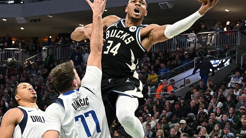Nov 18, 2023; Milwaukee, Wisconsin, USA; Milwaukee Bucks forward Giannis Antetokounmpo (34) drives to the basket against Dallas Mavericks guard Luka Doncic (77) in the first half at Fiserv Forum. Mandatory Credit: Michael McLoone-USA TODAY Sports