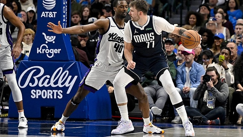 Nov 19, 2023; Dallas, Texas, USA; Dallas Mavericks guard Luka Doncic (77) looks to move the ball past Sacramento Kings forward Harrison Barnes (40) during the second half at the American Airlines Center. Mandatory Credit: Jerome Miron-USA TODAY Sports