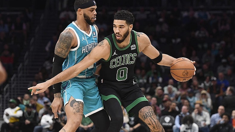 Nov 20, 2023; Charlotte, North Carolina, USA; Boston Celtics forward Jayson Tatum (0) looks to drive past Charlotte Hornets forward Miles Bridges (0) during the first half at the Spectrum Center. Mandatory Credit: Sam Sharpe-USA TODAY Sports
