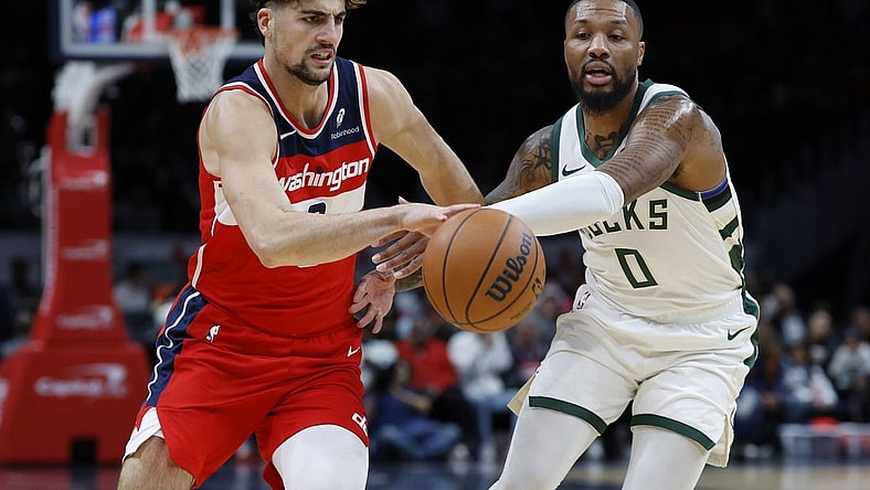 Nov 20, 2023; Washington, District of Columbia, USA; Washington Wizards forward Deni Avdija (8) drives to the basket as Milwaukee Bucks guard Damian Lillard (0) defends in the first quarter at Capital One Arena. Mandatory Credit: Geoff Burke-USA TODAY Sports