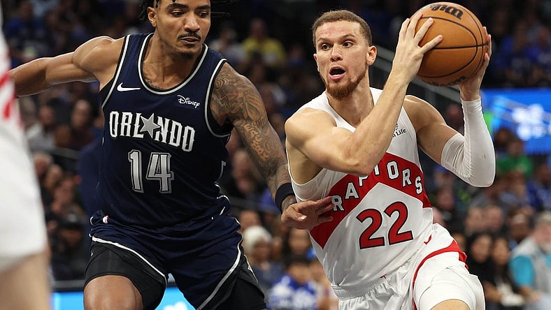 Nov 21, 2023; Orlando, Florida, USA;Toronto Raptors guard Malachi Flynn (22) drives to the basket as Orlando Magic guard Gary Harris (14) defends  during the second half at Amway Center. Mandatory Credit: Kim Klement Neitzel-USA TODAY Sports