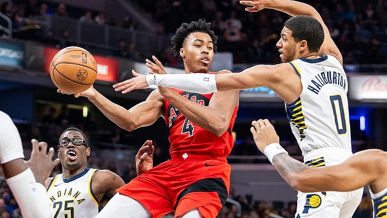 Nov 22, 2023; Indianapolis, Indiana, USA; Toronto Raptors forward Scottie Barnes (4) passes the ball while Indiana Pacers guard Tyrese Haliburton (0) defends in the first half at Gainbridge Fieldhouse. Mandatory Credit: Trevor Ruszkowski-USA TODAY Sports