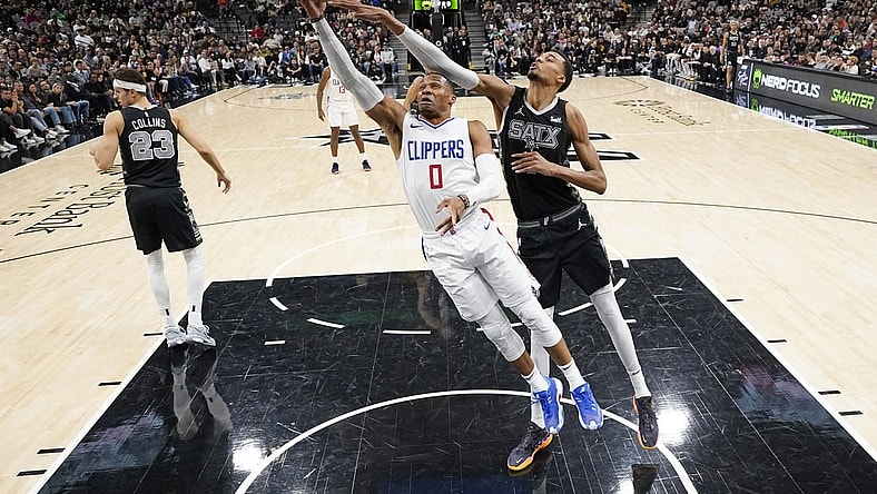 Nov 22, 2023; San Antonio, Texas, USA; Los Angeles Clippers guard Russell Westbrook (0) lays in a basket while defended by San Antonio Spurs forward Victor Wembanyama (1) during the second half at Frost Bank Center. Mandatory Credit: Scott Wachter-USA TODAY Sports