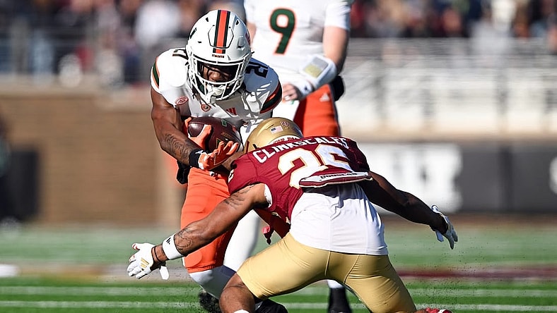 Nov 24, 2023; Chestnut Hill, Massachusetts, USA; Miami Hurricanes running back Henry Parrish Jr. (21) runs against Boston College Eagles defensive back CJ Clinkscales (26) during the first half at Alumni Stadium. Mandatory Credit: Brian Fluharty-USA TODAY Sports