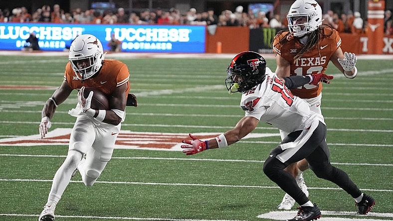 Nov 24, 2023; Austin, Texas, USA; Texas Longhorns running back Keilan Robinson (7) runs for a touchdown while defended by Texas Tech Red Raiders defensive back Bralyn Lux (12) during the first half at Darrell K Royal-Texas Memorial Stadium. Mandatory Credit: Scott Wachter-USA TODAY Sports