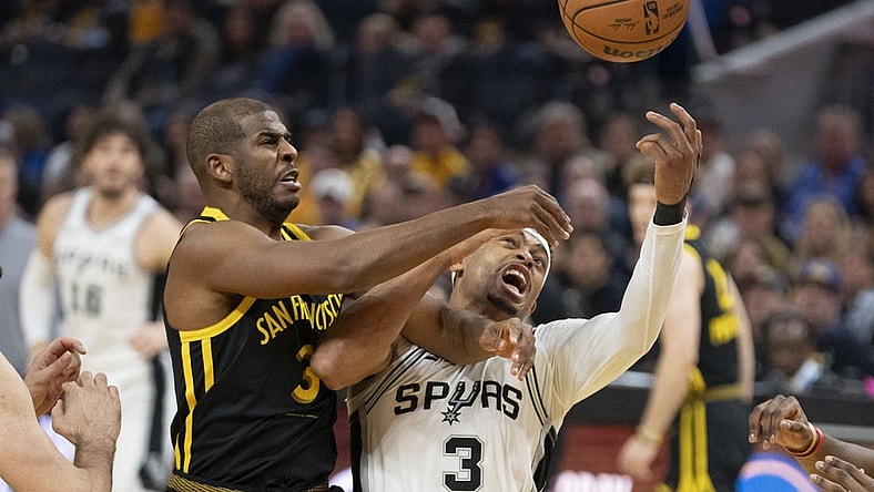 November 24, 2023; San Francisco, California, USA; Golden State Warriors guard Chris Paul (3, left) and San Antonio Spurs forward Keldon Johnson (3, right) fight for the rebound during the first quarter at Chase Center. Mandatory Credit: Kyle Terada-USA TODAY Sports