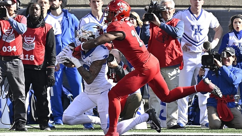 Nov 25, 2023; Louisville, Kentucky, USA;  Kentucky Wildcats wide receiver Dane Key (6) catches a touchdown pass under the pressure of Louisville Cardinals defensive back Storm Duck (29) during the first half at L&N Federal Credit Union Stadium. Mandatory Credit: Jamie Rhodes-USA TODAY Sports
