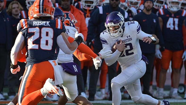 Nov 25, 2023; Champaign, Illinois, USA; Northwestern Wildcats quarterback Jack Lausch (12) rushes with the ball  during the first half against the Illinois Fighting Illini at Memorial Stadium. Mandatory Credit: Ron Johnson-USA TODAY Sports