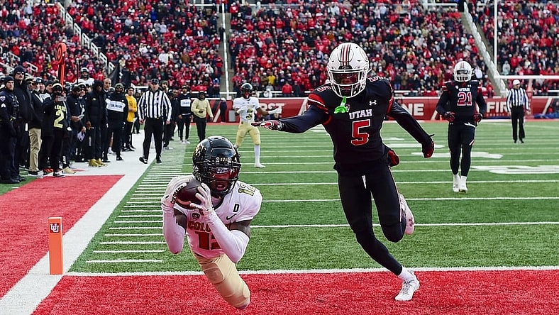 Nov 25, 2023; Salt Lake City, Utah, USA; Colorado Buffaloes athlete Travis Hunter (12) dives for a catch in the end zone in front of Utah Utes cornerback Zemaiah Vaughn (5) at Rice-Eccles Stadium. Mandatory Credit: Christopher Creveling-USA TODAY Sports