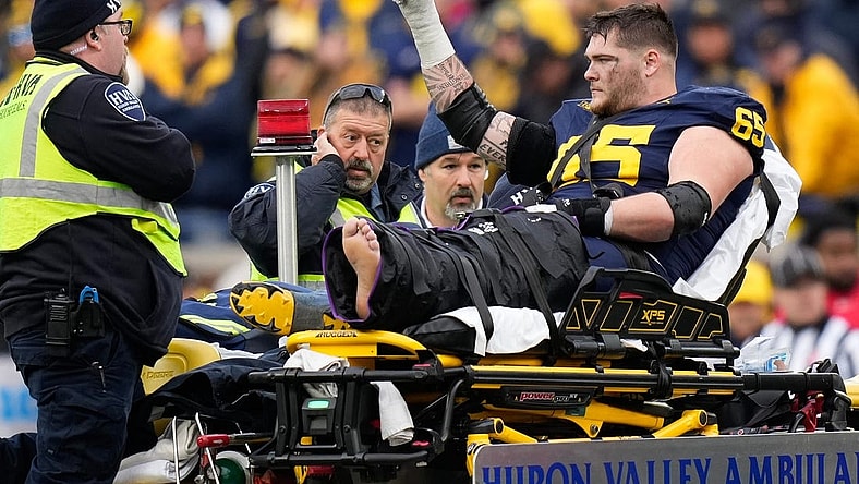 Nov 25, 2023; Ann Arbor, Michigan, USA; Michigan Wolverines offensive lineman Zak Zinter (65) is carted off by medics after an injury during the second half of the NCAA football game against the Michigan Wolverines at Michigan Stadium. Ohio State lost 30-24. Mandatory Credit: Adam Cairns-USA TODAY Sports