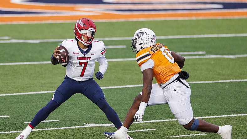 Nov 25, 2023; El Paso, Texas, USA; No. 22 Liberty Flames quarterback Kaidon Salter (7) tries to evade a UTEP Miners defensive end Maurice Westmoreland (0) during the first half at Sun Bowl Stadium. Mandatory Credit: Ivan Pierre Aguirre-USA TODAY Sports