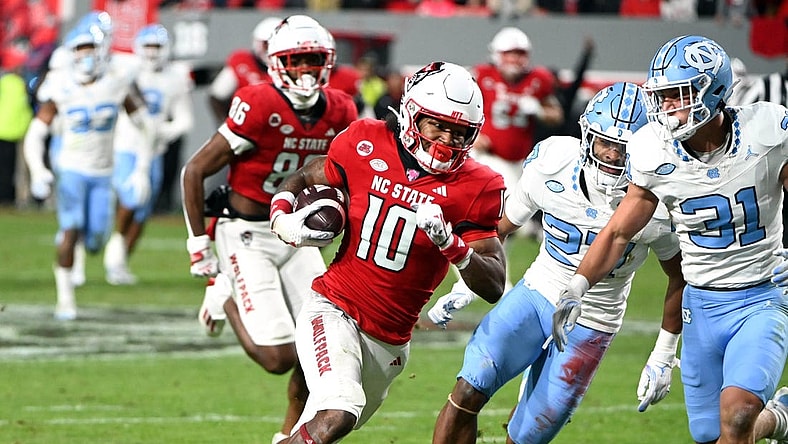 Nov 25, 2023; Raleigh, North Carolina, USA; North Carolina State Wolfpack receiver KC Concepcion (10) runs after a catch against North Carolina Tar Heels defensive back Will Hardy (31) during the first half at Carter-Finley Stadium. Mandatory Credit: Rob Kinnan-USA TODAY Sports