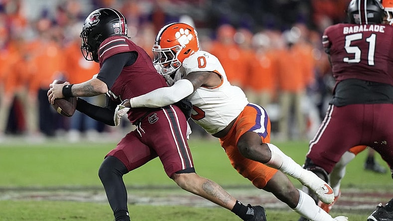 Nov 25, 2023; Columbia, South Carolina, USA; South Carolina Gamecocks quarterback Spencer Rattler (7) is sacked by Clemson Tigers linebacker Barrett Carter (0) in the first half at Williams-Brice Stadium. Mandatory Credit: David Yeazell-USA TODAY Sports