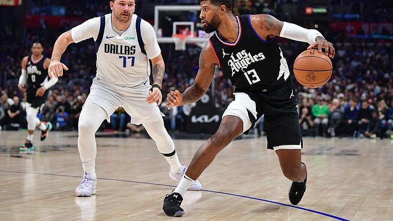 Nov 25, 2023; Los Angeles, California, USA; Los Angeles Clippers forward Paul George (13) moves the ball against Dallas Mavericks guard Luka Doncic (77) during the first half at Crypto.com Arena. Mandatory Credit: Gary A. Vasquez-USA TODAY Sports