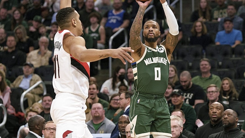 Nov 26, 2023; Milwaukee, Wisconsin, USA;  Milwaukee Bucks guard Damian Lillard (0) shoots against Portland Trail Blazers guard Malcolm Brogdon (11) during the first quarter at Fiserv Forum. Mandatory Credit: Jeff Hanisch-USA TODAY Sports