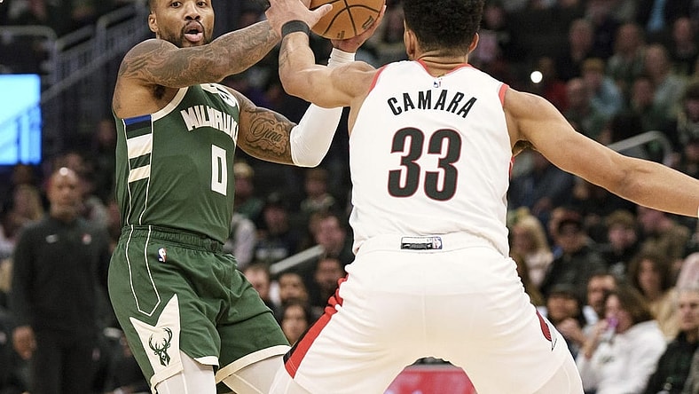 Nov 26, 2023; Milwaukee, Wisconsin, USA;  Milwaukee Bucks guard Damian Lillard (0) looks to pass the ball under pressure from Portland Trail Blazers forward Toumani Camara (33) during the first quarter at Fiserv Forum. Mandatory Credit: Jeff Hanisch-USA TODAY Sports