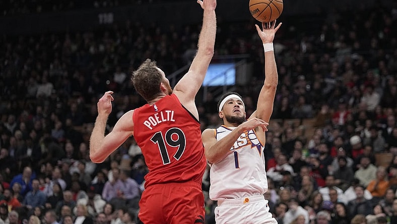 Nov 29, 2023; Toronto, Ontario, CAN; Phoenix Suns guard Devin Booker (1) shoots the ball as Toronto Raptors center Jakob Poeltl (19) defends during the first half at Scotiabank Arena. Mandatory Credit: John E. Sokolowski-USA TODAY Sports