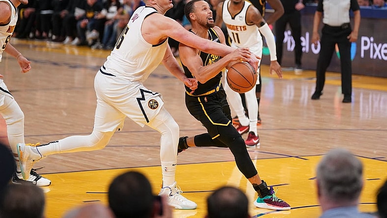 Apr 27, 2022; San Francisco, California, USA; Golden State Warriors guard Stephen Curry (30) has the ball knocked out of his hands by Denver Nuggets center Nikola Jokic (15) in the third quarter during game five of the first round for the 2022 NBA playoffs at Chase Center. Mandatory Credit: Cary Edmondson-USA TODAY Sports