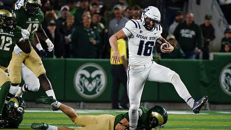 Oct 15, 2022; Fort Collins, Colorado, USA; Utah State Aggies quarterback Levi Williams (16) can't escape the grasp of a Colorado State Rams defender at Sonny Lubick Field at Canvas Stadium. Mandatory Credit: Michael Madrid-USA TODAY Sports