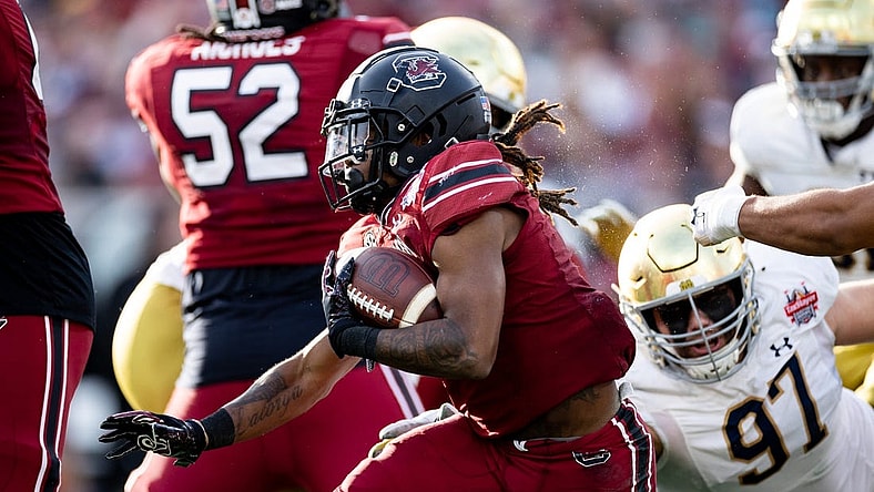 Dec 30, 2022; Jacksonville, FL, USA; South Carolina Gamecocks wide receiver Antwane Wells Jr. (3) runs with the ball away from Notre Dame Fighting Irish defensive lineman Gabriel Rubio (97) during the first half in the 2022 Gator Bowl at TIAA Bank Field. Mandatory Credit: Matt Pendleton-USA TODAY Sports