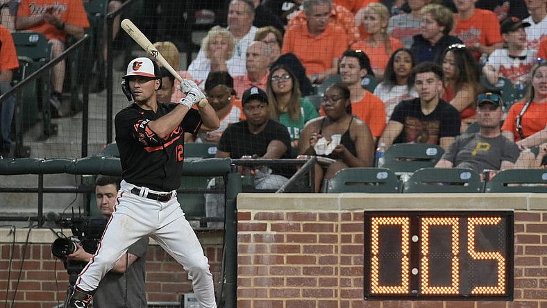 May 12, 2023; Baltimore, Maryland, USA;  Baltimore Orioles second baseman Adam Frazier (12) warms up next to the pitch clock during the third inning of the game against the Pittsburgh Pirates at Oriole Park at Camden Yards. Mandatory Credit: Tommy Gilligan-USA TODAY Sports