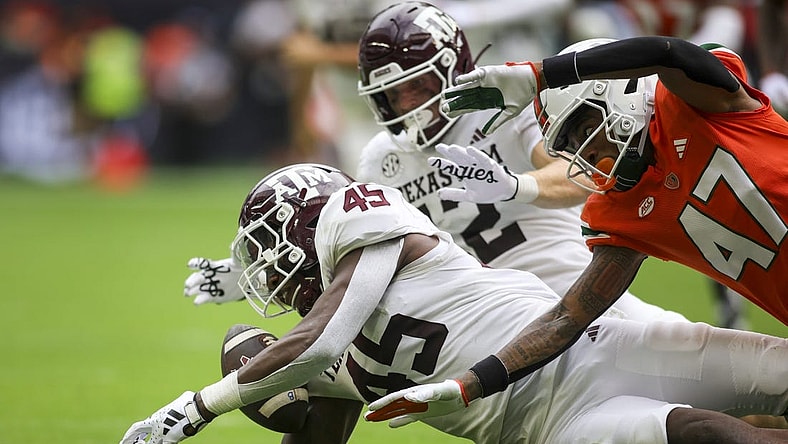 Aggies linebacker Edgerrin Cooper (45) recovers a fumble against the Miami Hurricanes during the second quarter at Hard Rock Stadium. Mandatory Credit: Sam Navarro-USA TODAY Sports