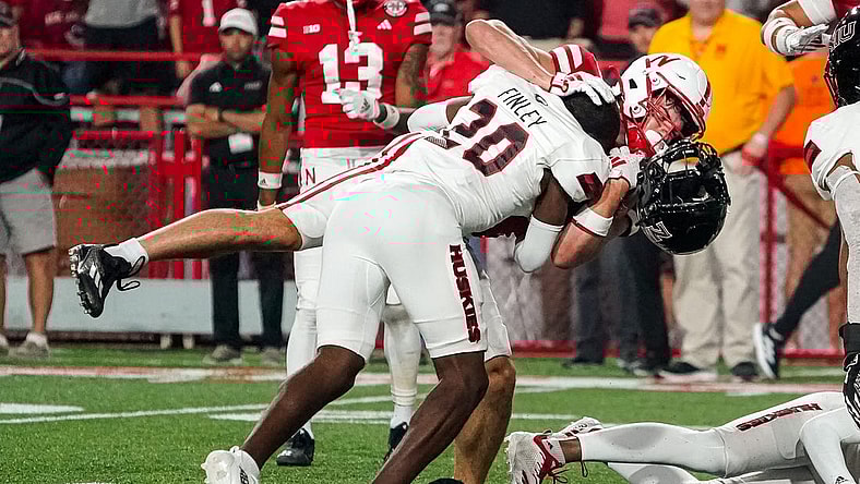 Sep 16, 2023; Lincoln, Nebraska, USA; Northern Illinois Huskies cornerback Jacob Finley (20) loses his helmet while tackling Nebraska Cornhuskers wide receiver Alex Bullock (84) during the third quarter at Memorial Stadium. Mandatory Credit: Dylan Widger-USA TODAY Sports
