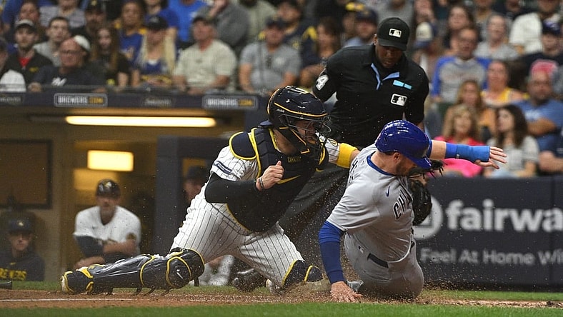 Sep 30, 2023; Milwaukee, Wisconsin, USA; Chicago Cubs left fielder Ian Happ (8) is tagged out by Milwaukee Brewers catcher Victor Caratini (7) in the fourth inning at American Family Field. Mandatory Credit: Michael McLoone-USA TODAY Sports