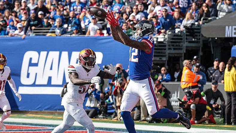 Oct 22, 2023; East Rutherford, New Jersey, USA; New York Giants tight end Darren Waller (12) catches a touchdown pass during the first half in front of Washington Commanders linebacker Cody Barton (57) at MetLife Stadium. Mandatory Credit: Vincent Carchietta-USA TODAY Sports