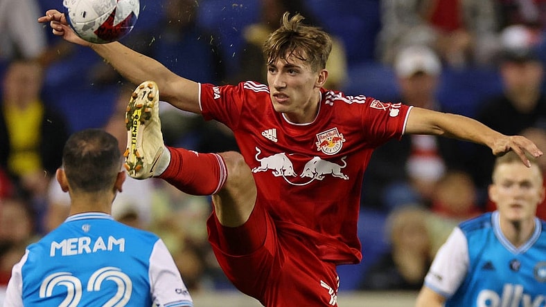 Oct 25, 2023; Harrison, NJ, USA; New York Red Bulls midfielder Daniel Edelman (75) kicks the ball against Charlotte FC forward Justin Meram (22) during the second half in the Eastern Conference Wild Card match of the 2023 MLS Cup Playoffs at Red Bull Arena. Mandatory Credit: Vincent Carchietta-USA TODAY Sports
