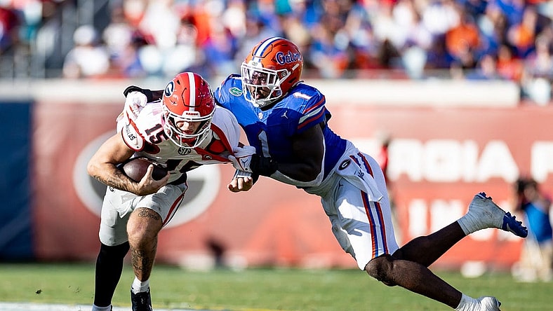 Florida Gators defensive end Princely Umanmielen (1) tackles Georgia Bulldogs quarterback Carson Beck (15) during the first half at Everbank Stadium in Jacksonville, FL on Saturday, October 28, 2023. [Matt Pendleton/Gainesville Sun]