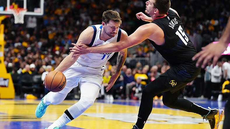Nov 3, 2023; Denver, Colorado, USA; Denver Nuggets center Nikola Jokic (15) fouls Dallas Mavericks guard Luka Doncic (77) in the third quarter at Ball Arena. Mandatory Credit: Ron Chenoy-USA TODAY Sports