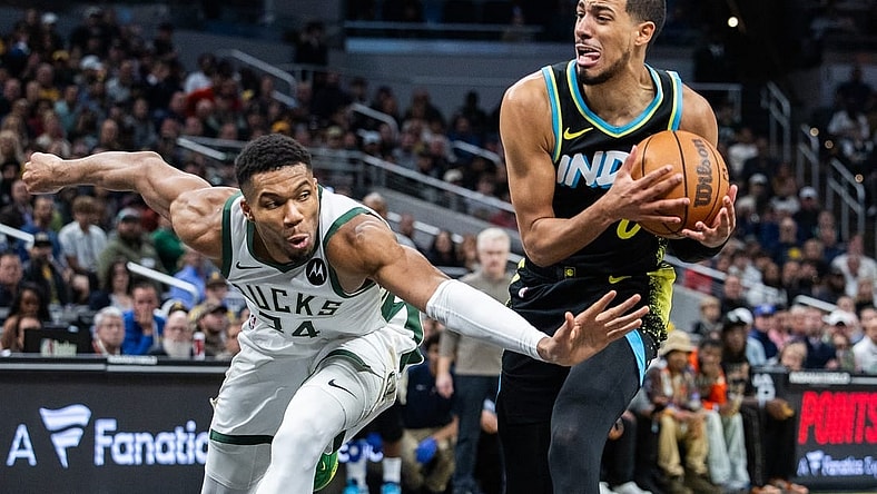 Nov 9, 2023; Indianapolis, Indiana, USA; Indiana Pacers guard Tyrese Haliburton (0) dribbles the ball while Milwaukee Bucks forward Giannis Antetokounmpo (34) defends in the second half at Gainbridge Fieldhouse. Mandatory Credit: Trevor Ruszkowski-USA TODAY Sports