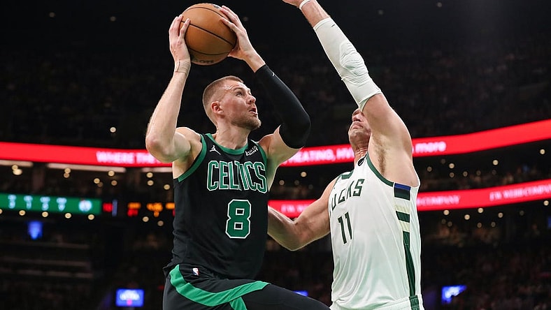 Nov 22, 2023; Boston, Massachusetts, USA; Boston Celtics center Kristaps Porzingis (8) drives to the basket defended by Milwaukee Bucks center Brook Lopez (11) during the first half at TD Garden. Mandatory Credit: Paul Rutherford-USA TODAY Sports