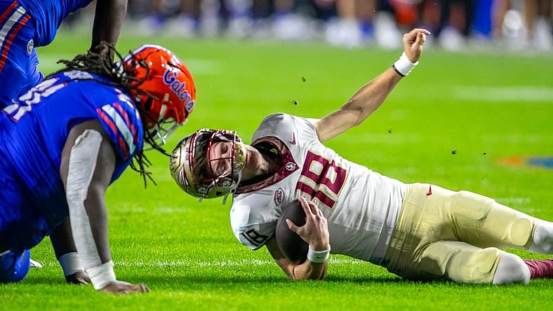 Florida Gators defensive lineman Desmond Watson (21) sacks Florida State Seminoles quarterback Tate Rodemaker (18) during second half action as Florida takes on Florida State at Steve Spurrier Field at Ben Hill Griffin Stadium in Gainesville, FL on Saturday, November 25, 2023. [Alan Youngblood/Gainesville Sun]