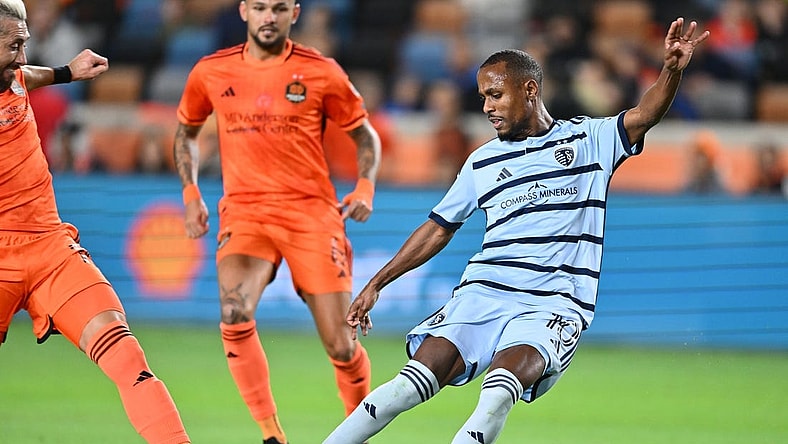 Nov 26, 2023; Houston, Texas, USA; Sporting Kansas City midfielder Gadi Kinda (10) shoots the ball against Houston Dynamo midfielder Hector Herrera (16) during the first half for the MLS Cup Western Conference Semifinal match at Shell Energy Stadium. Mandatory Credit: Maria Lysaker-USA TODAY Sports