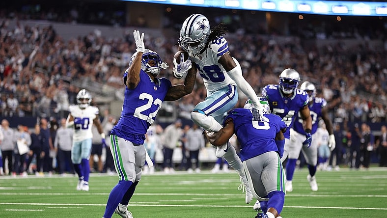Nov 30, 2023; Arlington, Texas, USA; Dallas Cowboys wide receiver CeeDee Lamb (88) is tackled by Seattle Seahawks cornerback Tre Brown (22) and safety Quandre Diggs (6) during the first half at AT&T Stadium. Mandatory Credit: Tim Heitman-USA TODAY Sports